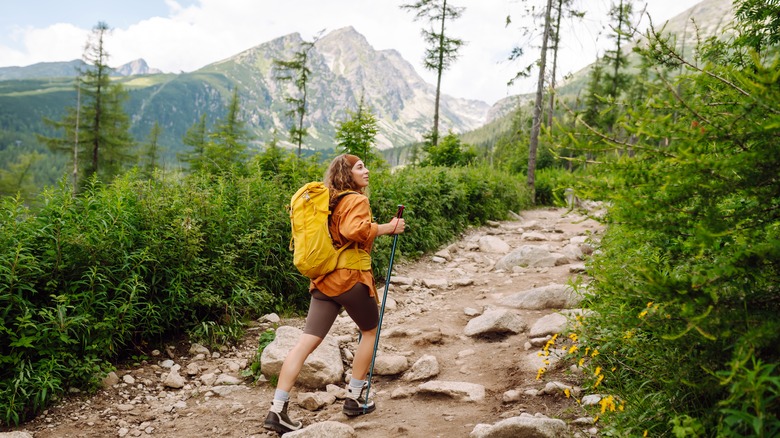 Woman looks at plants while hiking