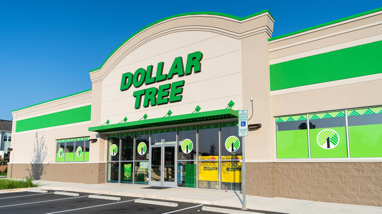 Parking space in front of the white and green entrance to a Dollar Tree.