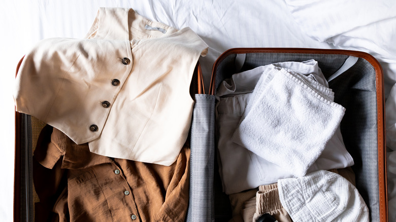 An open suitcase full of vacation clothes