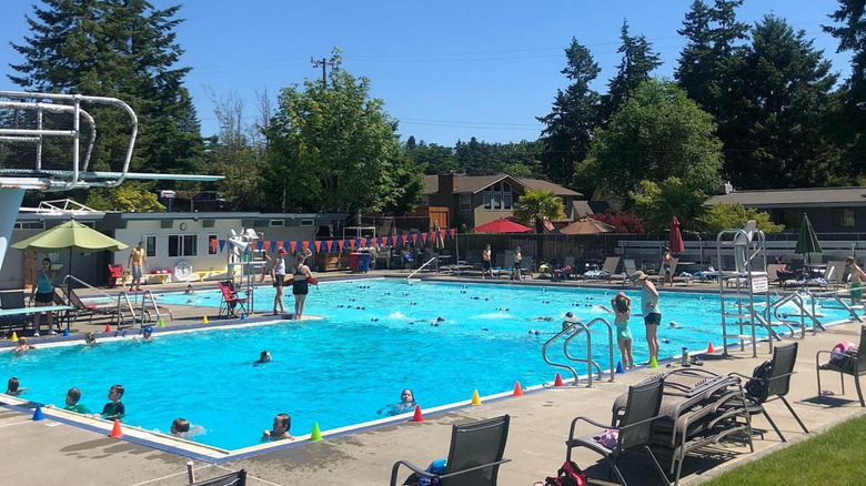 People enjoying community swimming pool on sunny day