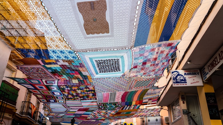 Multi-colored crochet canopy stretched over a street Alhaurín de la Torre, Spain