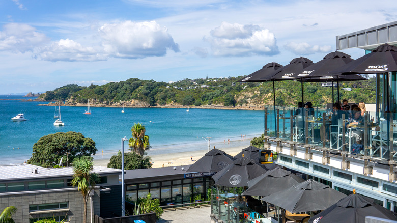 Restaurant with umbrellas overlooking beach in Oneroa.