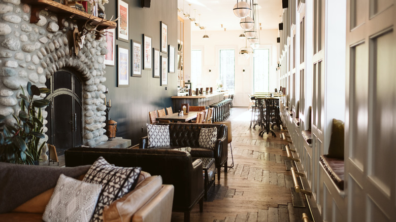 restaurant with tables, couches, and a fireplace