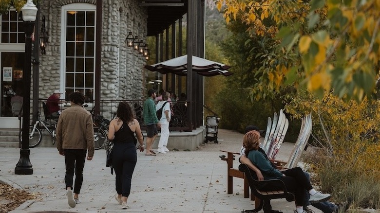 people walking and sitting in front of a hotel