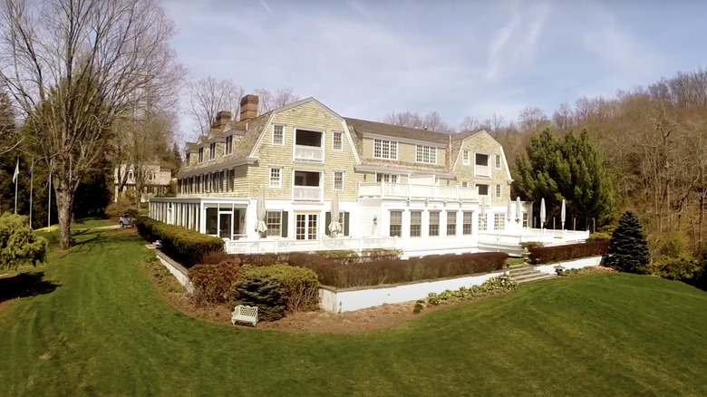 Exterior view of Mayflower Inn, Connecticut surrounded by trees.