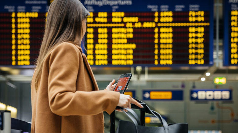 Traveler checking their mobile in an airport departure lounge