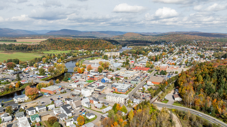 An aerial view of Saint-Raymond shows several shorter buildings with a river winding throuh.