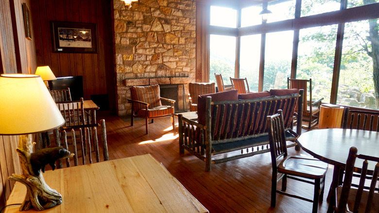 Luray, VA -2021: Hotel lobby and terrace view Skyland Resort in Shenandoah National Park. Stone fireplace, rustic furniture, lamp with black bear. Windows to view Shenandoah Valley.