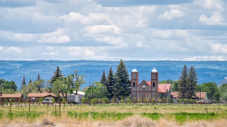 Highway 285 with cityscape of Conejos and oldest church in Colorado