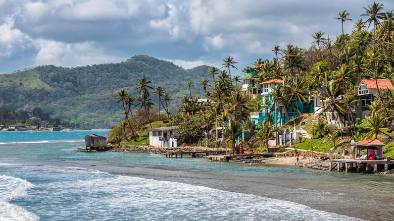 A beachfront setting with colorful homes and palm trees on Isla Colon, Panama