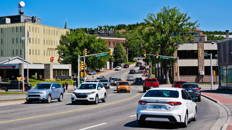 Cars driving along Main Street on a bright, clear day in Corner Brook, NL