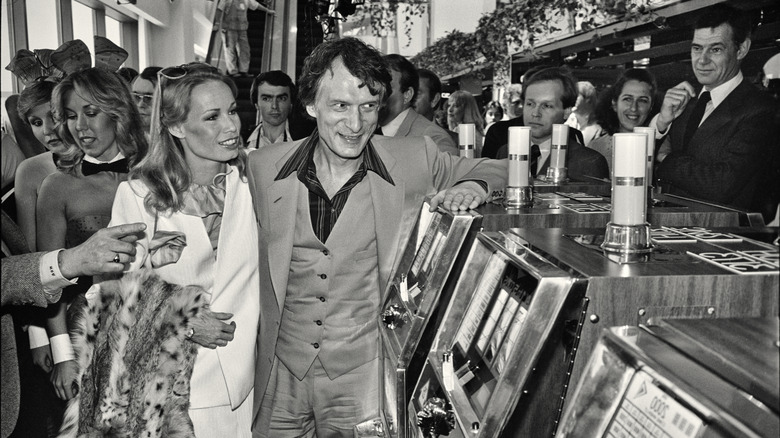 Hugh Hefner and Playboy Bunnies pose before slot machines in ab Atlantic City Casino in the 1980s