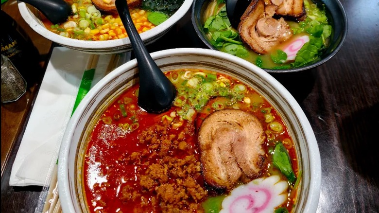 Three colorful bowls of ramen sitting on a table