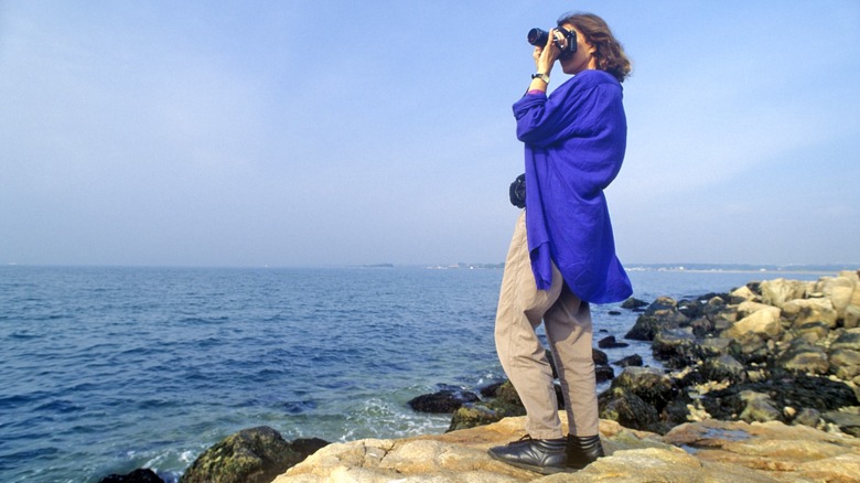 A photographer taking pictures from cliffs overlooking the ocean at Bluff Point State Park in Connecticut
