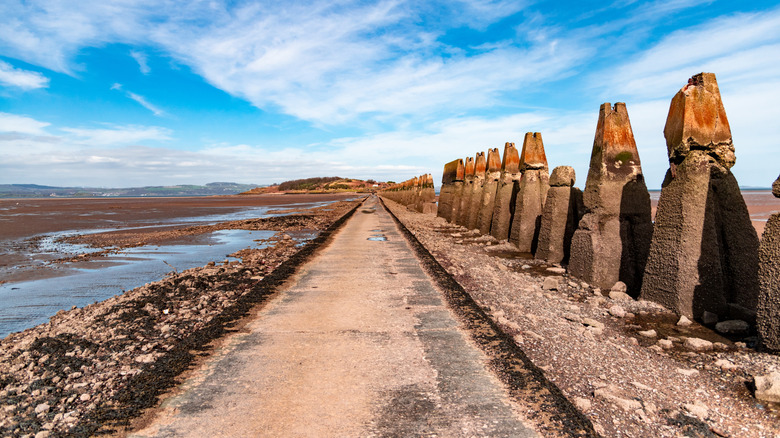Causeway to Cramond Island in Edinburgh, Scotland, emerged at low tide. To the side, appears a WWII anti-tank barricade