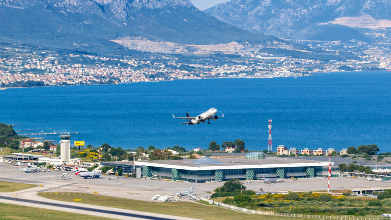 An airplane taking off from Croatia mountain coast