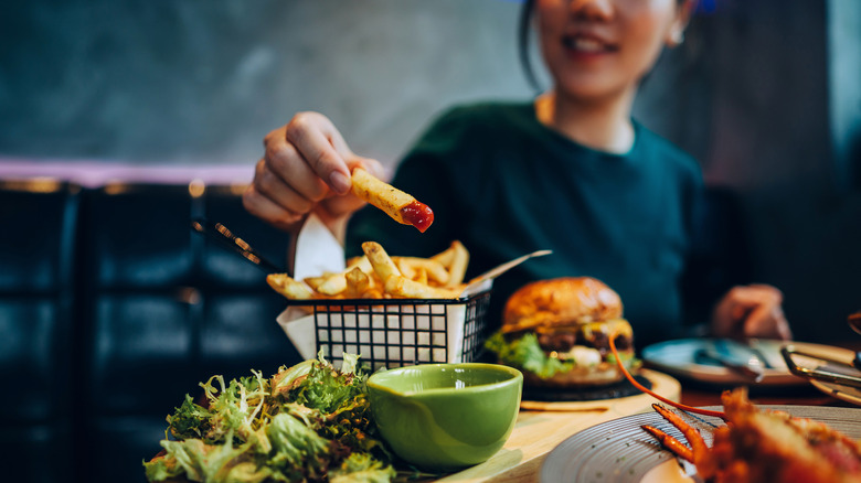 Woman eating a burger and fries