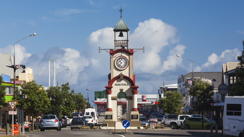 Clock tower on city street with cars
