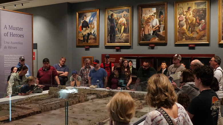 Tourists looking at an exhibit inside the Alamo