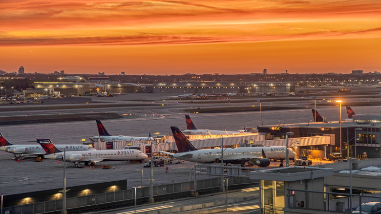 Planes on the runway at an airport at sunset