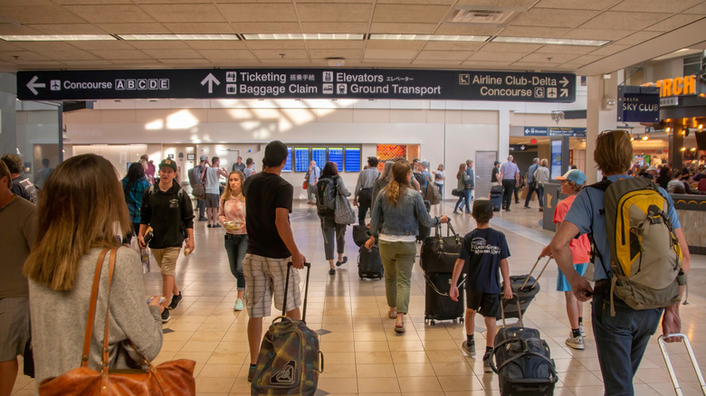 Passengers with luggage walking inside the airport
