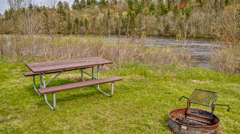 Picnic table and fire pit with grill at a river campsite on the St. Croix National Scenic Riverway