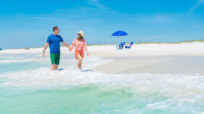 Couple walking in the clears waters of Pensacola Beaches