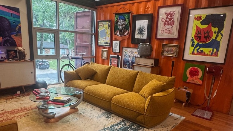 Living room inside Prince Road Container House in Florida, with a couch and art on the walls
