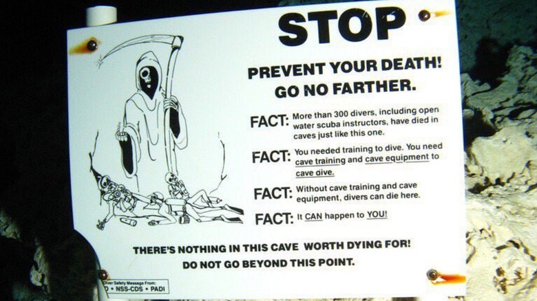 An underwater sign with a Grim Reaper and warnings of death if divers proceed into Eagle's Nest Sinkhole in Florida