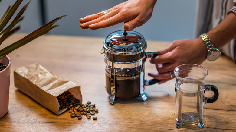 Person pushing down French press lid