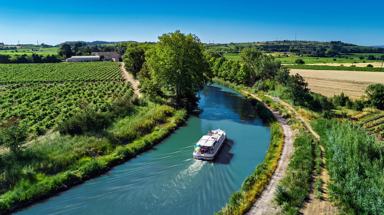 A houseboat on the Canal du Midi in France surrounded by green fields