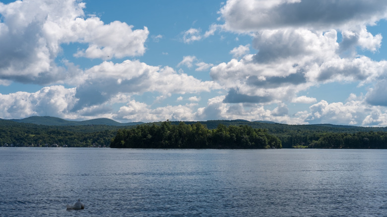 white fluffy clouds drift over the calm blue waters of Lake Bomoseen, Castleton