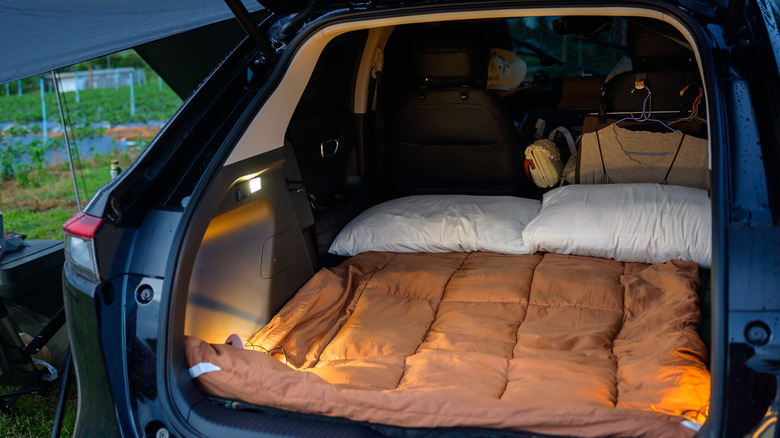 Car camping with blankets and pillows in back of car