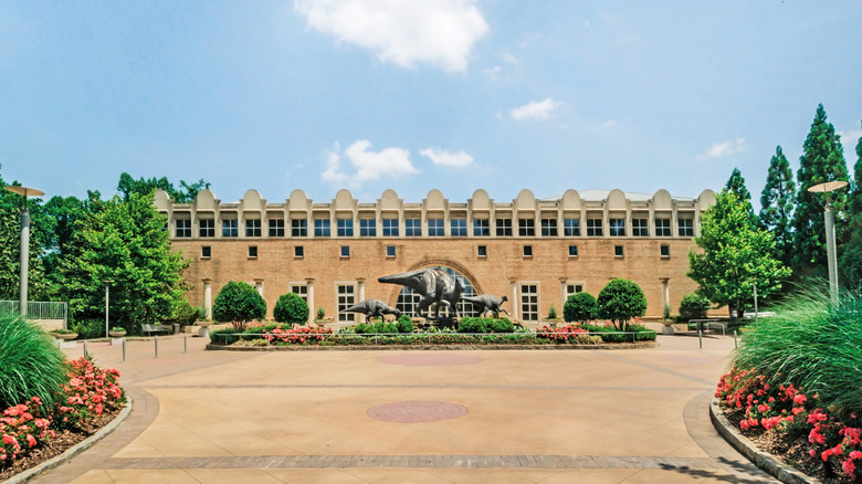 The entrance leading to Fernbank Museum, with dinosaur statues in front
