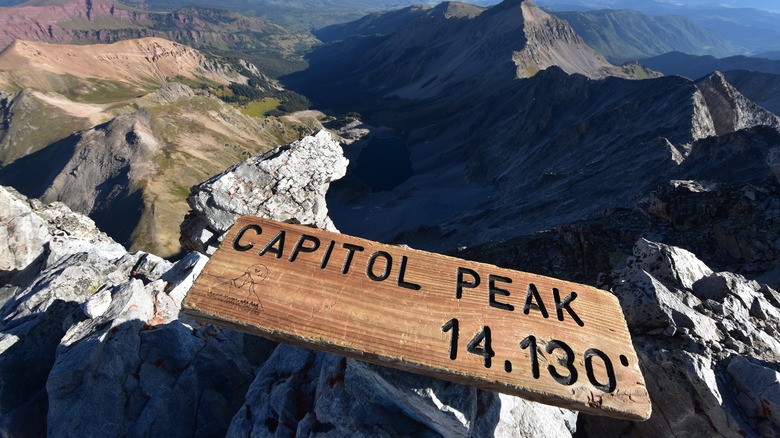 sign and view from Capitol Peak summit