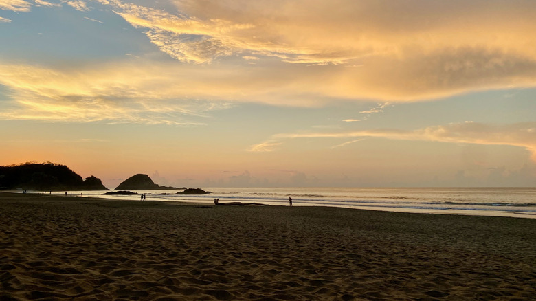 Mazunte beach with people walking along shore