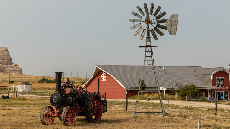 Red building old tractor run by Chimney Rock Museum gray sky
