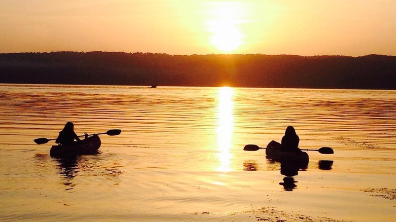 Two people kayaking at sunset on a Lake Guntersville