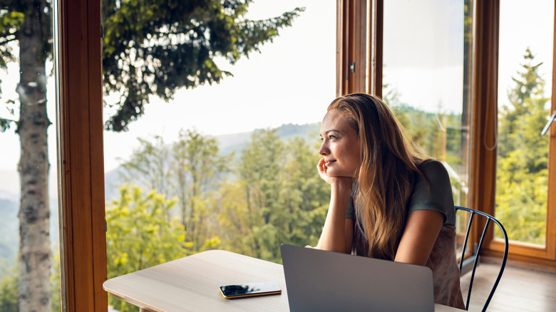 woman staring dreamily out from cabin window