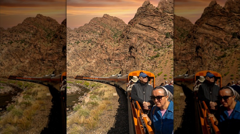 People standing on an open-air passenger car on a ride between Durango and Silverton on the Durango and Silverton Narrow Gauge Railroad