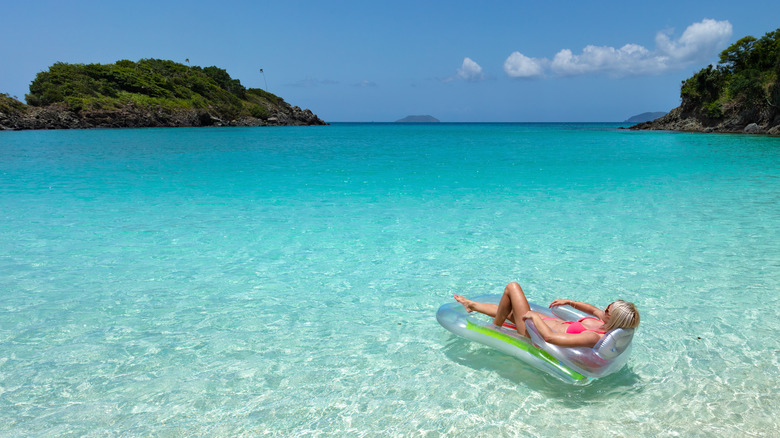 Woman floating on raft at beach