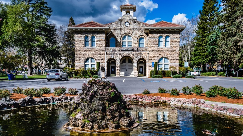 Historic stone building with clock tower and fountain in the foreground, Sonoma Plaza in California