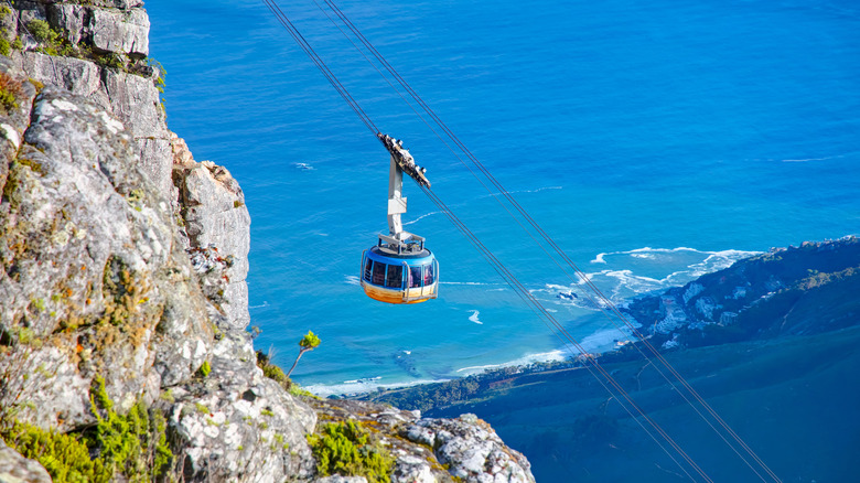Cable car heading up Table Mountain with coastline in the background