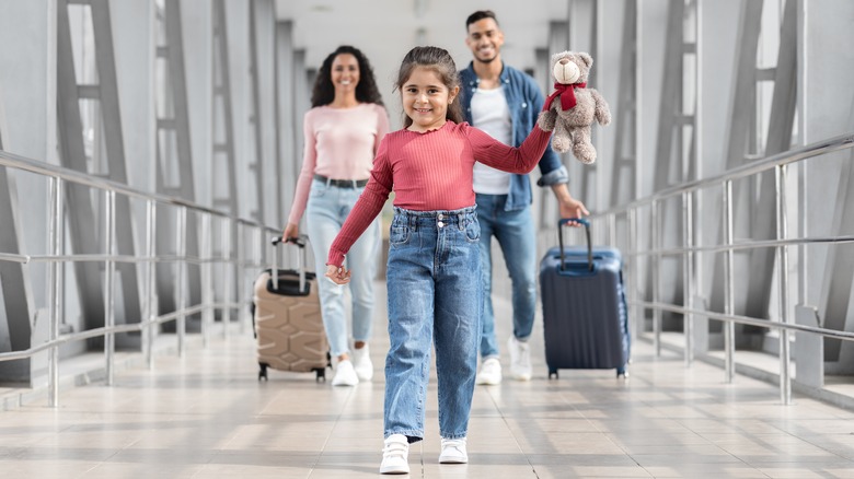 Family walking down airport hallway