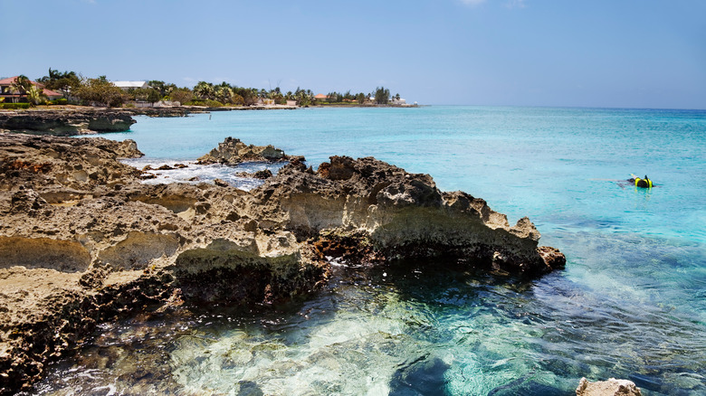 snorkeler by rocky outcropping ocean