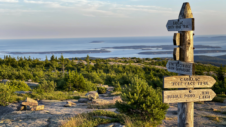 Wooden directional signs overlook the ocean in the coastal town of Bar Harbor from the top of Cadillac Mountain in Acadia National Park, Maine