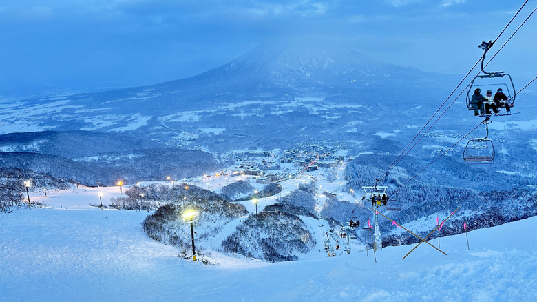Skiers in lifts during dusk at Niseko United