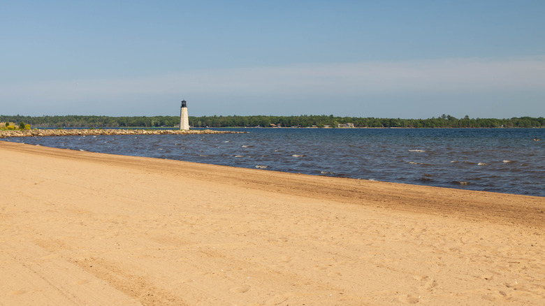 Escanaba beach with a lighthouse on a peninsula in the distance