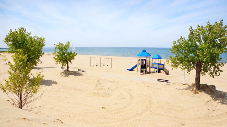 Playground and trees on sandy beach in Jean Klock Park.