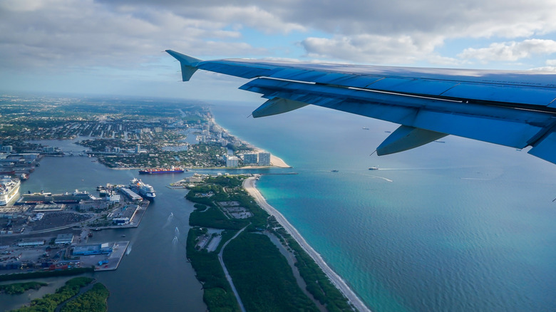 Aerial view of Port Everglades Cruiseport as passenger plane takes off Fort Lauderdale Airport in Florida